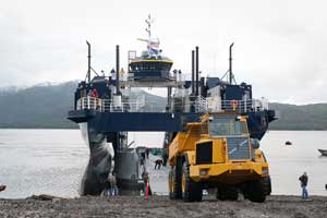 A dump truck rolls from the vechicle deck of the M/V Susitna directly onto the beach